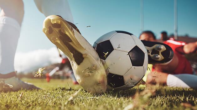 Soccer, soccer ball and man slide tackle during match, training or competition outdoors. Football, sports and football players on grass field for workout, fitness or exercise game on football pitch Fußball, Fußball und Mann beim Grätschen während eines Spiels, Trainings oder Wettkampfs im Freien. Fußball, Sport und Fußballspieler auf Rasenplatz beim Training, Fitness oder Spiel auf dem Fußballplatz. Fußball, Fußballplatz, Kreisliga, Amateurfußball