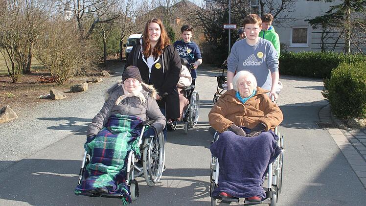 Vanessa Schöttner, Christian Wenig und David Buß sowie Praktikant Jakob van Plüren gehen mit den Senioren spazieren.