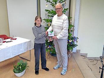 Schulleiter Christian Buchner überreicht der Gewinnerin ihren Preis.