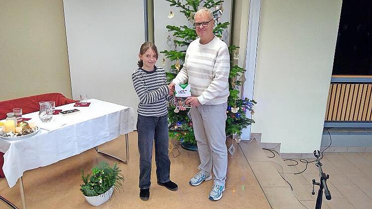 Schulleiter Christian Buchner überreicht der Gewinnerin ihren Preis.
