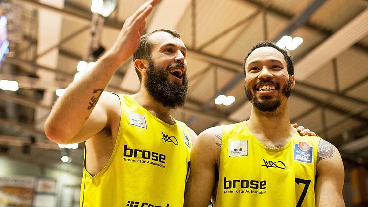 Bastian Doreth (links) und Sieggarant Kyan Anderson strahlen nach dem dritten Saisonsieg mit Medi Bayreuth um die Wette. Foto: Christoph Worsch