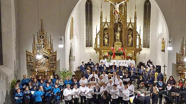 Der spontane Gemeinschaftschor am Schluss des Konzerts: Die Angels, der Gesangverein C&auml;cilia und der Ministrantenchor (von links) sangen "We are the world", im Hintergrund der Musikverein Wallenfels. Foto: Franz Behrschmidt