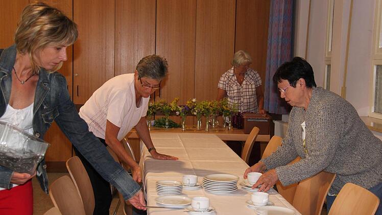 Während Gabi Hoch (2 von links) und Karin Kühe (rechts) die Tischdecken auflegen, verteilt Daniela Feser das Besteck.