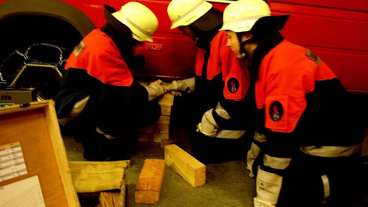 Simon Seidl, Felix Winterer und Tim Duda (von links) unterbauen ein Fahrzeug, um einen Verletzten befreien zu können.