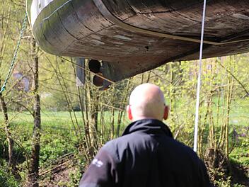 Helmut Fischer schaut der "Kissingen" hinterher, die gerade von einem Krahn ins Wasser gehoben wird und in der Luft schwebt. Foto: Benedikt Borst