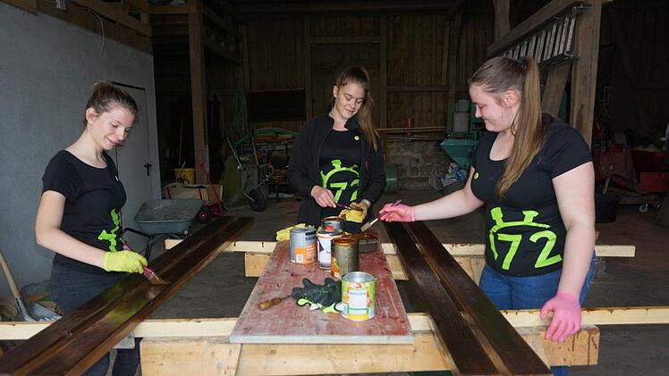 Marie Jaborek, Paulina Leitsch, Julia Schneider haben das Holz für die Bänke beim Modloser Brunnen neu gestrichen. Foto: Marion Eckert
