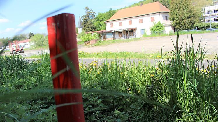 Bisher markieren vier rote Stäbe die Stelle, an die das zukünftige Trafohäuschen hinkommen soll: Und zwar gegenüber der Bahnhofshalle am Hang. Foto: Julia Raab