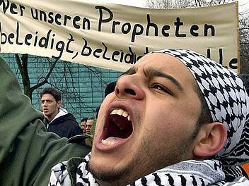 Das Archivbild zeigt einen jungen Muslim, der im Jahr 2006 in Berlin gegen die Mohammed-Karikaturen demonstriert. Fotos: S. Pilick /dpa/Ronald Rinklef