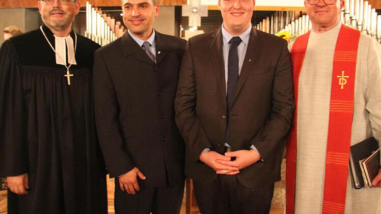 Dekan Thomas Kretschmar (links) bei seiner ersten Amtshandlung und Diakon Martin Neukamm (rechts) von der Rummelsberger Diakonie ernannten Christian Hanf (Zweiter von links), den bisherigen Dekanatsjugendreferenten, zum Verwaltungsdiakon, und Stefan Ludwig zum neuen Dekantsjugendreferent. Foto: Sonny Adam