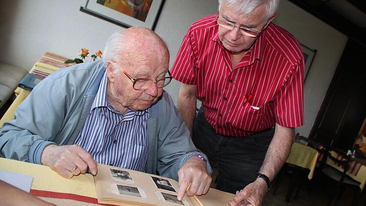 Zeitzeuge Elmar Dippold zeigt Axel Harnier ein Fotoalbum mit Aufnahmen aus den 1930er- und 1940er-Jahren, wobei sie das besondere Augenmerk auf die Fotos aus seiner Kindheit in Romansthal legten. Foto: Matthias Einwag