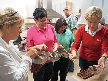 Unter den Augen der Teilnehmer des Workshops f&uuml;llte Monika Wagner (rechts) die Pralinenf&ouml;rmchen. Hierzu braucht es Geschick.  Foto: ee