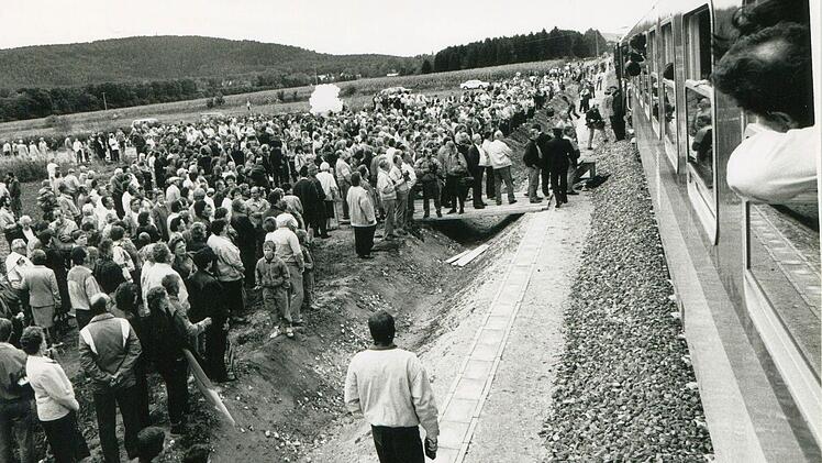So schnell ändern sich die Zeiten: War die Bahnstrecke kurz hinter Wildenheid 1989 noch zugewachsen (linkes Bild), drängten sich schon knapp zwei Jahre später die Menschenmassen bei der Wiedereröffnung an der Bahnstrecke. Ganz vorne im Zug saß Ernst Fleischmann. Fotos: CT-.Archiv (2) / Berthold Köhler (1)