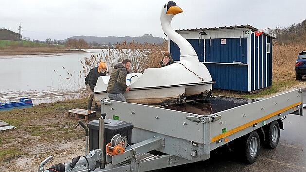 J&ouml;rg Wieland (Zweiter von links) l&auml;dt mit seinen Helfern eines der Schwanen-Tretboote auf seinen H&auml;nger.