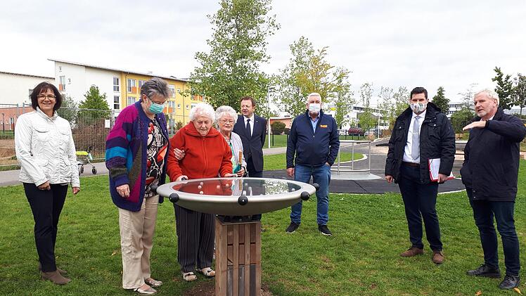 Bewohnerinnen des Wohnheims "Am Park" schauen sich den neuen Murmeltisch an. Gisela Raab, Thomas Schwesinger, Norbert Tessmer, OB Dominik Sauerteig und Bernhard Ledermann, Leiter des Grünflächenamtes, (von links) freuen sich über dieses zusätzliche Spielelement.  Foto: Louay Yassin