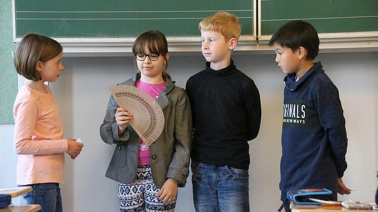 Lara (von links), Tina, Matthias und Karl proben eine Szene. Im Mittelpunkt steht Karola von Luxburg, die von Tina dargestellt wird. Soeben erklären die Mädchen die sogenannte Fächersprache. Foto: Kathrin Kupka-Hahn