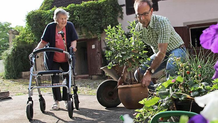 Ein einfacher Handgriff kann oft eine große Erleichterung sein. Gerhard Nützel von der Nachbarschaftshilfe Burghaslach hilft Ursula Gertz mit ihren Blumentöpfen.  Foto: Christian Bauriedel