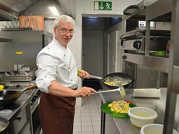 Küchenchef Klaus Brückner bereitet sämtliche Gerichte in seiner Küche frisch zu. Hier füllt er einen Teller mit einer Variation aus Bandnudeln, Flusskrebsen und Spargel. Foto: Kathrin Kupka-Hahn