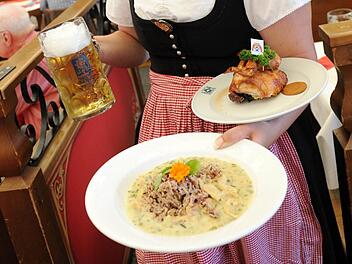 Vegan liegt im Trend: Auch auf dem Oktoberfest in München gibt es bereits vegane Gerichte. Hier zeigt eine Bedienung eine Portion veganes Hühnerfrikassee und ein halbes Wiesn-Hendl. Archivfoto: Tobias Hase/dpa