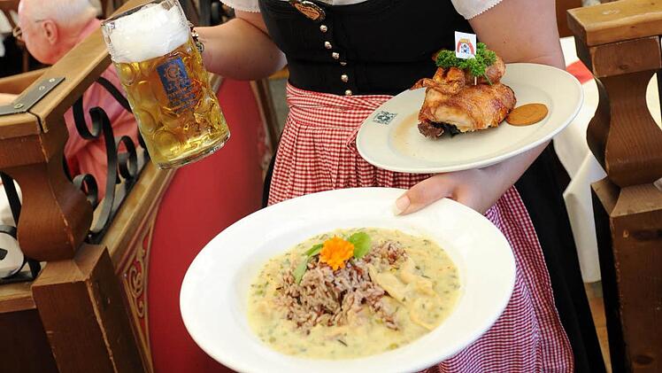 Vegan liegt im Trend: Auch auf dem Oktoberfest in München gibt es bereits vegane Gerichte. Hier zeigt eine Bedienung eine Portion veganes Hühnerfrikassee und ein halbes Wiesn-Hendl. Archivfoto: Tobias Hase/dpa