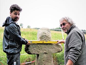 Restaurator Clemens M. Muth (rechts) und sein Sohn brachten das Sühnekreuz aus dem 14. Jahrhundert in die richtige Position. Fotos: Werner Reißaus