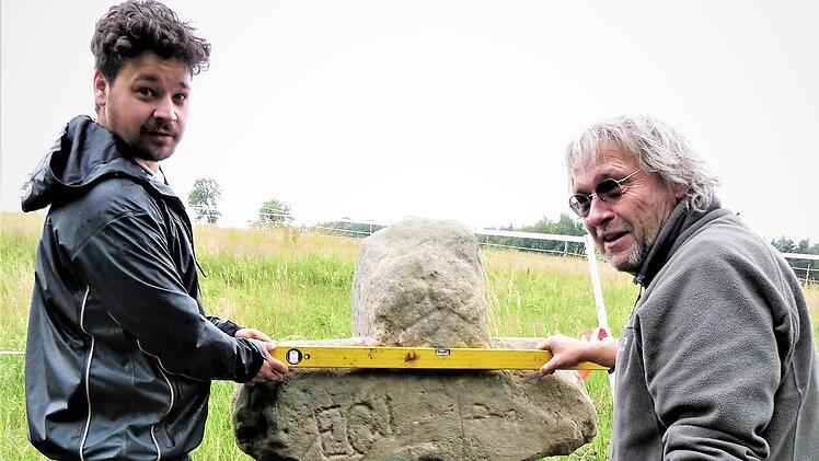 Restaurator Clemens M. Muth (rechts) und sein Sohn brachten das Sühnekreuz aus dem 14. Jahrhundert in die richtige Position. Fotos: Werner Reißaus