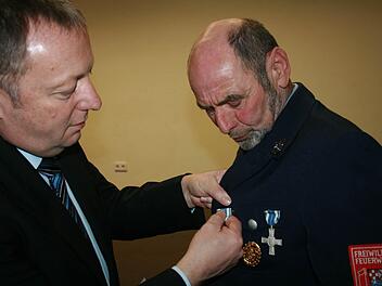 Landrat Thomas Bold steckt Ewald Halbig für 40 Jahre aktiven Dienst das Feuerwehr-Ehrenzeichen an. Fotos: Gabriele Sell