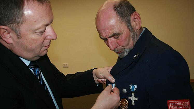 Landrat Thomas Bold steckt Ewald Halbig für 40 Jahre aktiven Dienst das Feuerwehr-Ehrenzeichen an. Fotos: Gabriele Sell