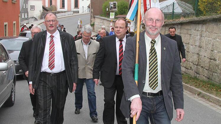 Nach der Fahnenübergabe trägt Hauptwanderwart Karl Schoger die Fahne von der Grafengehaiger Kirche bis zur Frankenwaldhalle.