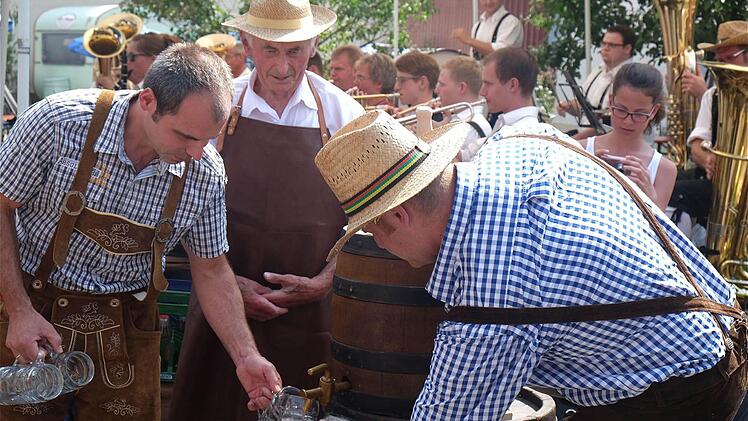 Schaumiger Auftakt: August Winter (hinten), einer der ältesten Einwohner, stach das Festbierfass an. Foto: Gerd Schaar