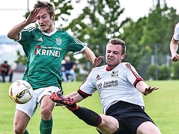 Der Herbstadter Julian Ankenbrand (rechts) muss sich m&auml;chtig strecken, um den Sander Lukas Hager den Ball wegzuspitzeln. Foto: Ryan Evans