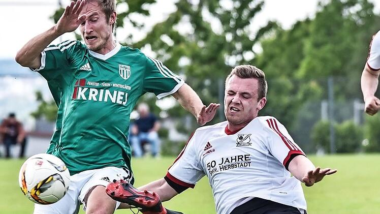 Der Herbstadter Julian Ankenbrand (rechts) muss sich m&auml;chtig strecken, um den Sander Lukas Hager den Ball wegzuspitzeln. Foto: Ryan Evans
