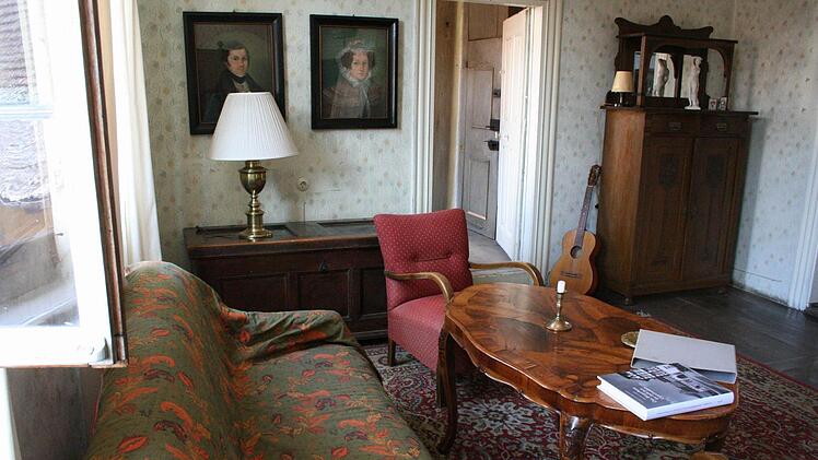 Das Boudoir ist geschmackvoll als kleines Wohnzimmer eingerichtet. Die geöffnete Tür führt in das Schlafzimmer der Hausherrin.