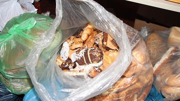Schoko-Bananen und Cremetörtchen mit Brötchen in einem großen Sack. Empfindliches Gebäck übersteht diese Behandlung nicht. Die Tafel-Mitarbeiterinnen können das ihren Kunden nicht mehr verkaufen und müssen es wegwerfen. Foto: Dagmar Besand