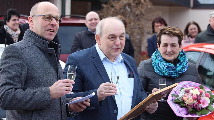 Bürgermeister Gerd Kleinhenz (links) überreicht die Urkunde zur Ernennung als Ehrenbürger des Marktes Wildflecken an Amtsvorgänger Alfred Schrenk (Mitte). Für Ehefrau Rosi gab es einen Blumenstrauß. Foto: Sebastian Schmitt-Mathea