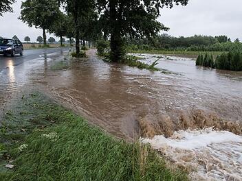 Wasser flie&szlig;t am 25.07.2017 am Rande einer Stra&szlig;e in Springe (Niedersachsen) und &uuml;berflutet Felder. Dauerregen hat in vielen Teilen Deutschlands zu &Uuml;berschwemmungen gef&uuml;hrt. Die Rettungskr&auml;fte sind im Dauereinsatz. Foto: Swen Pf&ouml;rtner/dpa