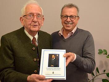 Kreisheimatpfleger Werner Eberth überreichte dem stellvertretenden Kissinger Landrat Emil Müller eines der ersten Exemplare seines jüngsten Buches mit dem Titel " Fürstbischof Julius Echter und seine Bauinschriften".  Foto: Peter Rauch
