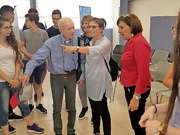 Sch&uuml;ler der Ort-School f&uuml;hren den Ehemann und die Tochter von Hanah Pines, deren Schicksal auf einem Banner dargestellt ist, durch die Ausstellung. Mit im Bild Schulleiterin Liora Hagin (2. v. r.)  Foto: Sivan