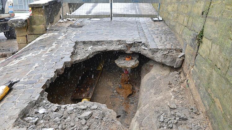 Ein großes Lock klafft im Weg neben der Mauer. In der Schweinfurter Straße ist eine kleine Stützmauer abgesackt und muss instand gesetzt werden. Daher ist der Maienbrunnen zwischen der Abzweigung zum Abtsberg und Schweinfurter Straße bis voraussichtlich Freitag, 4. Januar, für den Verkehr komplett gesperrt. Foto: Ronald Rinklef