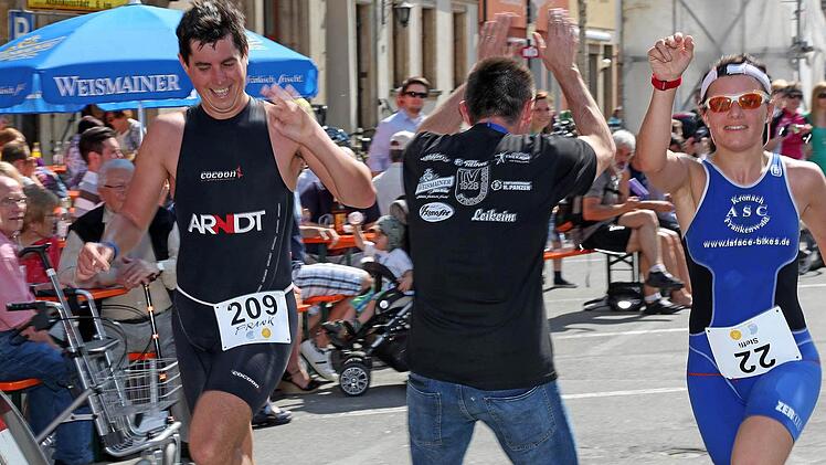 Triathlon-Organisator Helmut Dorsch ließ es sich nicht nehmen die Finisher abzuklatschen. Hier der Paareinlauf von Frank Neumann und Steffi Paulus (ASC Kronach Frankenwald). Foto: Klaus Gagel
