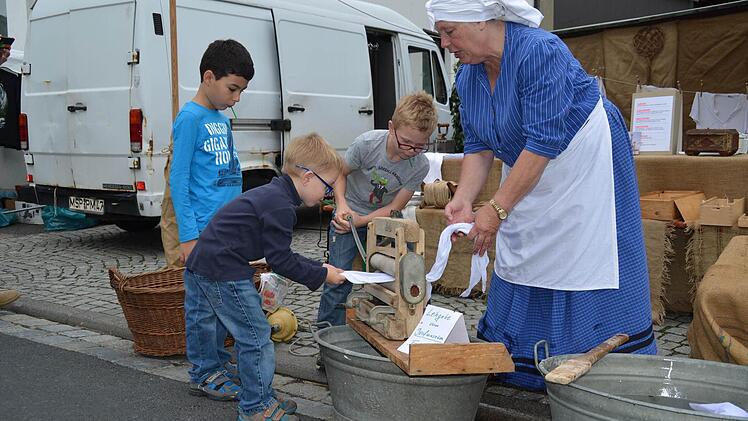 Carsten (links) und Julian leiern mit Annemarie Leuschner Wäsche durch die Mangel. Ihr Freund Arturo schaut zu. Foto: Kathrin Kupka-Hahn