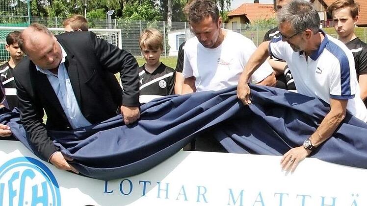 Mit dem FCH-Vorsitzenden Walter Nussel (li.) und dem sportlichen Leiter Rudi Litz (re.) enthüllt Lothar Matthäus das Schild. Zu diesem Zeitpunkt wusste der Ex-Profi noch nicht, was unter der Decke steckt. Nachdem er sich bedankt hatte ("Das macht mich stolz und ist eine große Ehre") merkte Matthäus schmunzelnd an: "Das müsst ihr fei auch aufhängen."  Fotos: Daniel Ruppert
