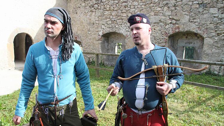 Die beiden erläutern, aus welchen Materialien Armbrüste gebaut wurden.