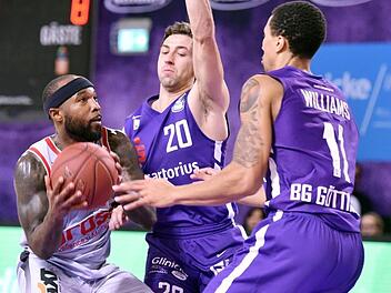 Tyrese Rice (links) wird von den Göttingern Michael Stockton und Penny Williams (rechts), der im Pokalduell wegen einer Fußverletzung fehlte, gestoppt. Foto: Hubert Jelinek