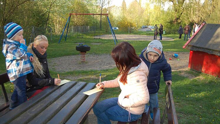Zwei junge Mütter mit ihren Söhnen füllen ihre Spielplatz-Wunschzettel aus. Foto: Sigismund von Dobschütz