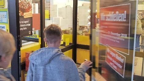 Noch öffnet sich die Ladentüre, doch ein Plakat am Eingang (rechts) kündigt die Schließung zum Jahreswechsel an.