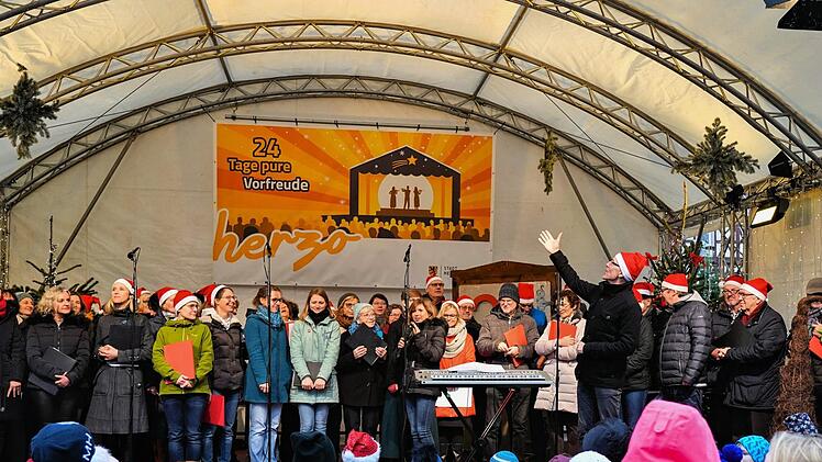 Toni Rotter und sein Erwachsenenchor traten aus dem letzten Türchen. Moderatorin Claudia Belzer (am Mikrofon) bedankt sich bei den Darbietenden. Fotos: Birgit Jentsch/herzolife