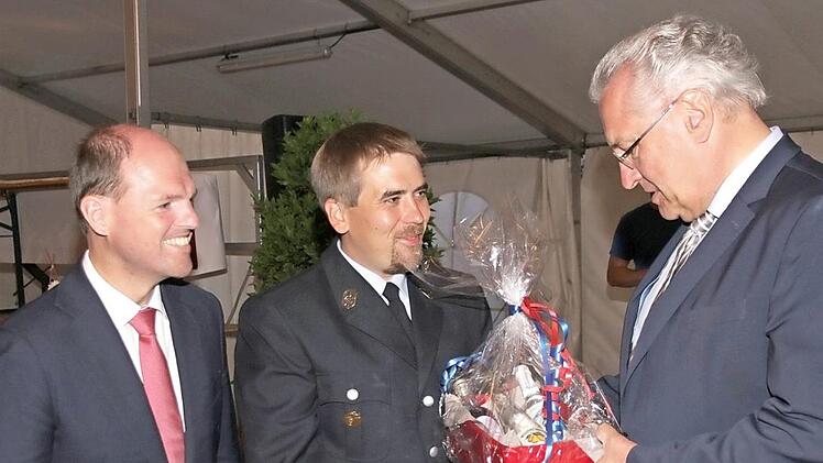 MdL Michael Hofmann und der Vorsitzende der Bammersdorfer Wehr, Dominik Hassa, übergeben Innenminister Joachim Herrmann ein Gastgeschenk.  Fotos: Matthias Erlwein