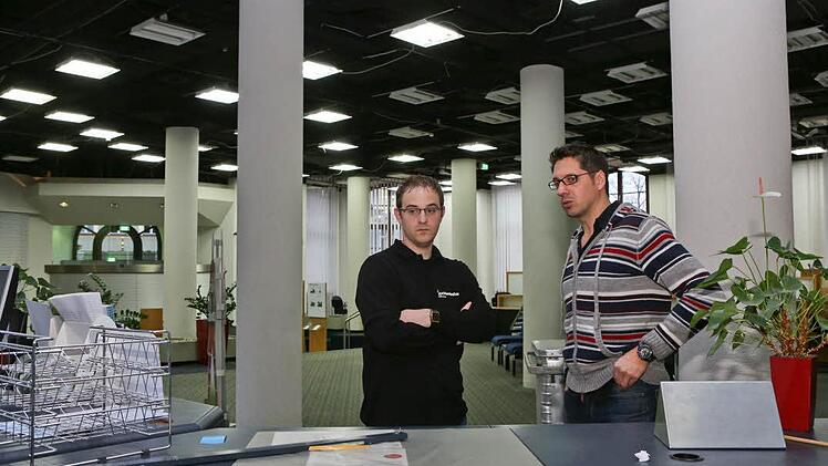 Filialleiter Carsten Beßler (links) bespricht mit Kai Dittrich vom Umzugsunternehmen letzte Einzelheiten in der schon leeren Schalterhalle.