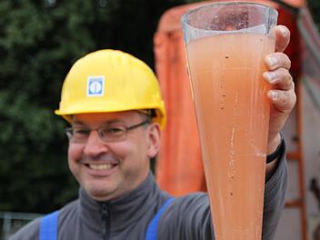 Markus Brandl zeigt die Brühe, die derzeit noch aus dem Brunnen gepumpt wird. Foto: Ulrike Müller