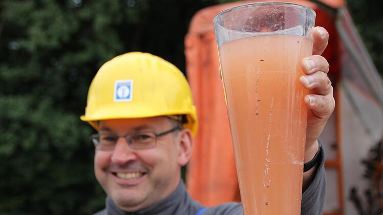 Markus Brandl zeigt die Brühe, die derzeit noch aus dem Brunnen gepumpt wird. Foto: Ulrike Müller